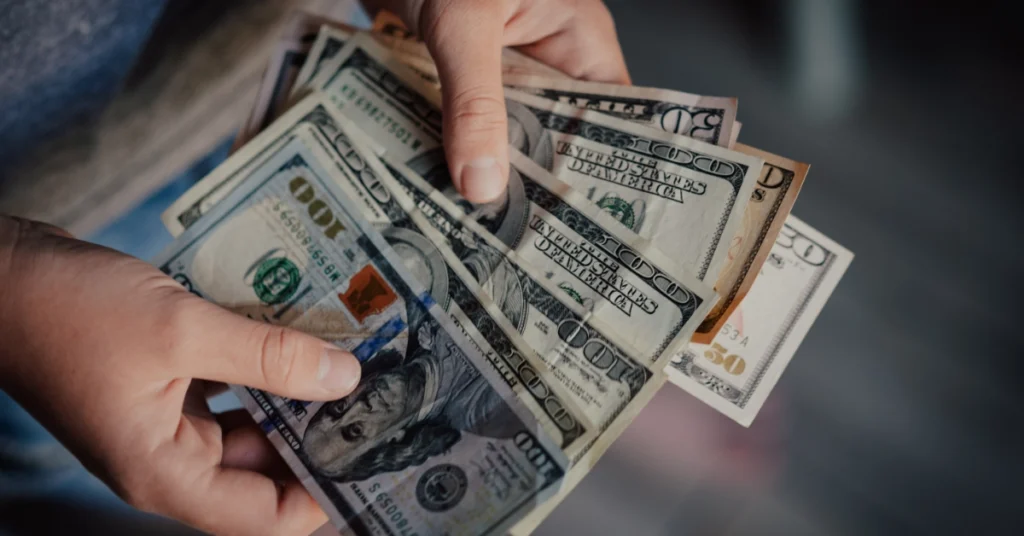 Hands counting cash representing HMRC tax payments and financial records